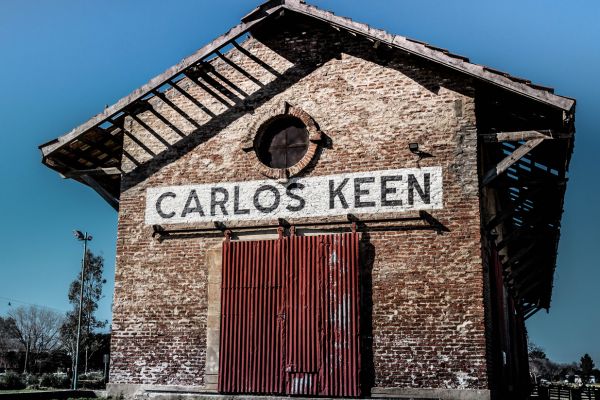 Image of old building with black and white sign with name Carlos Keen written on it.