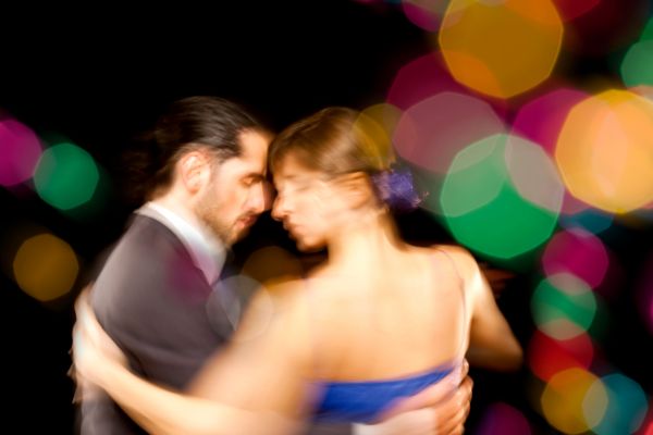 Image of couple dancing with colourful lights in background