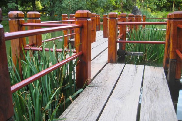 Zigzagging footbridge in Jardín Japonés in Buenos Aires, surrounded by lush greenery and tranquil water.