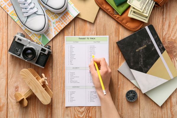 Image of hand holding pencil over a packing checklist.