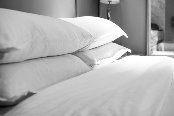 Image of white pillows on a neatly made bed.