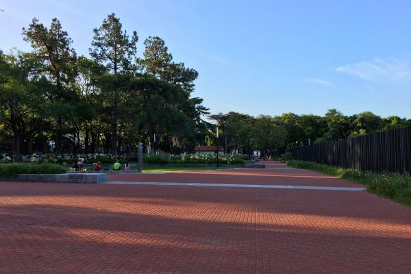 Park outside the gates of Olivos, the official residence of the President of Argentina, featuring lush greenery, trees, and peaceful walking paths.