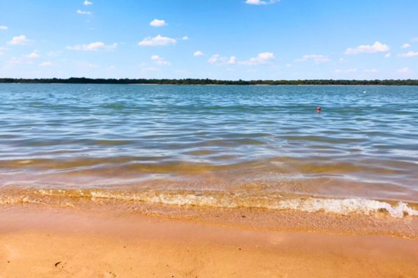 A scenic view of the Uruguay River flowing through Entre Ríos province, seen from a beach during summer.