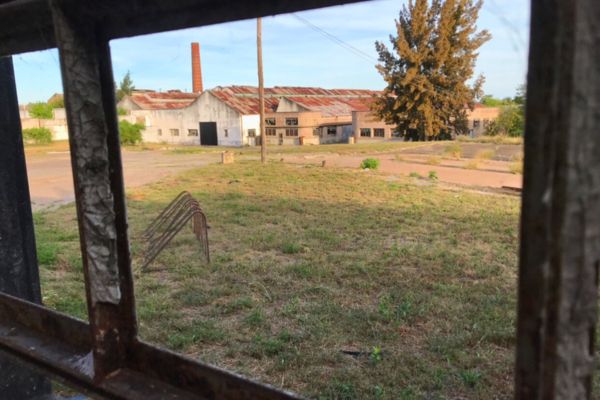 The abandoned Liebig corned beef factory with its tall chimney still standing prominently against the sky, surrounded by crumbling structures.