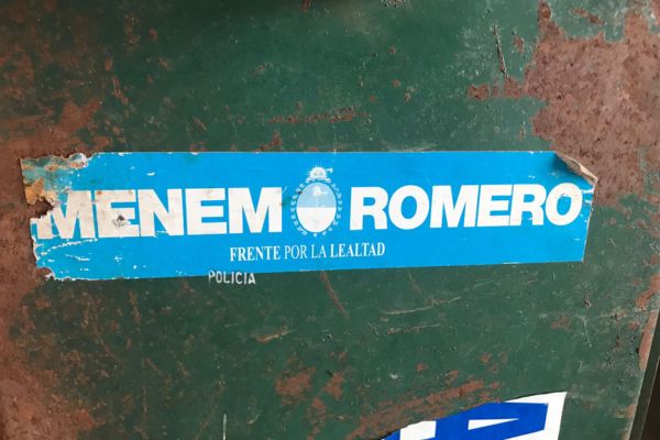 Old stickers from Carlos Menem's political campaigns stuck on rusted, abandoned lockers inside the derelict factory in Liebig, Argentina.