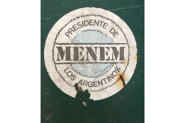 Old stickers from Carlos Menem's political campaigns stuck on rusted, abandoned lockers inside the derelict factory in Liebig, Argentina.