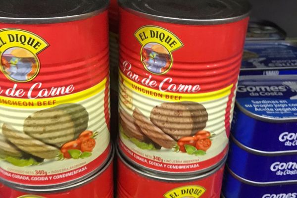 Tins of "Pan de Carne" (Beef Luncheon) displayed on a supermarket shelf in Argentina.