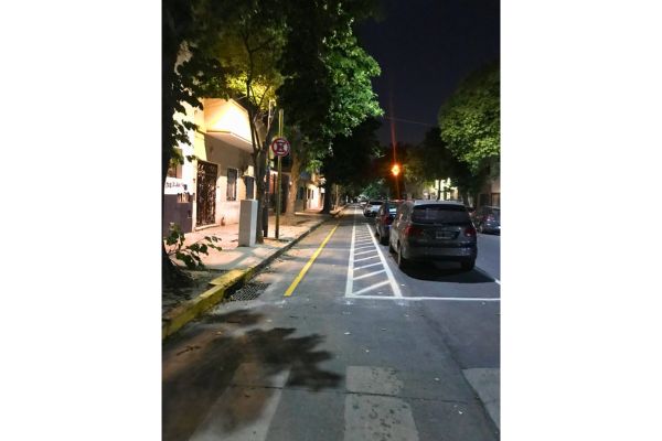 An empty cycle lane on a Buenos Aires street at night, illuminated by streetlights.